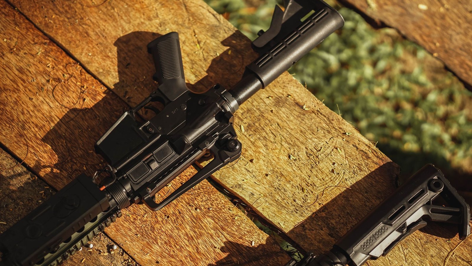 AR-style rifle on a wooden bench.