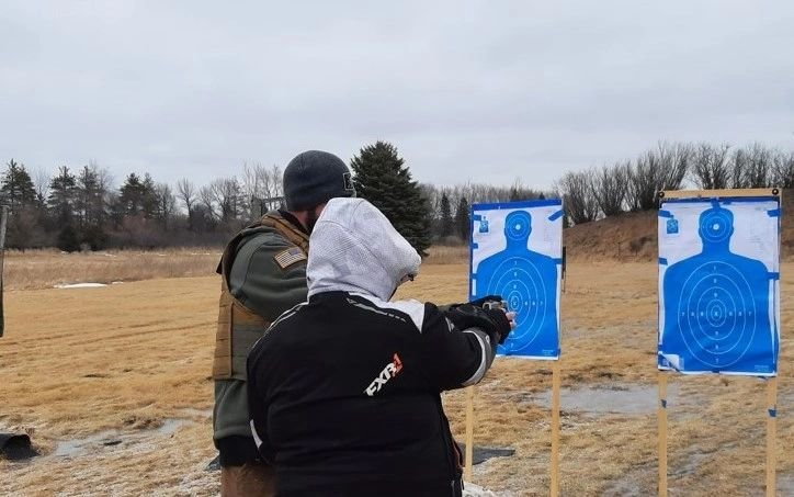 Two students on the firing line with silhouette targets.
